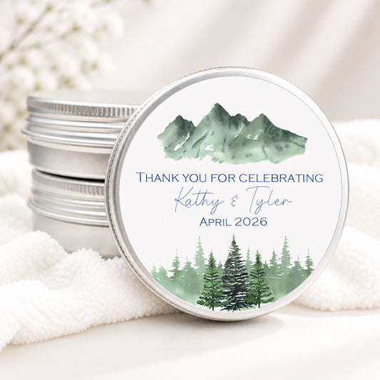 Personalized mountain wedding candle favor in a silver tin featuring a watercolor mountain landscape with custom names and wedding date.