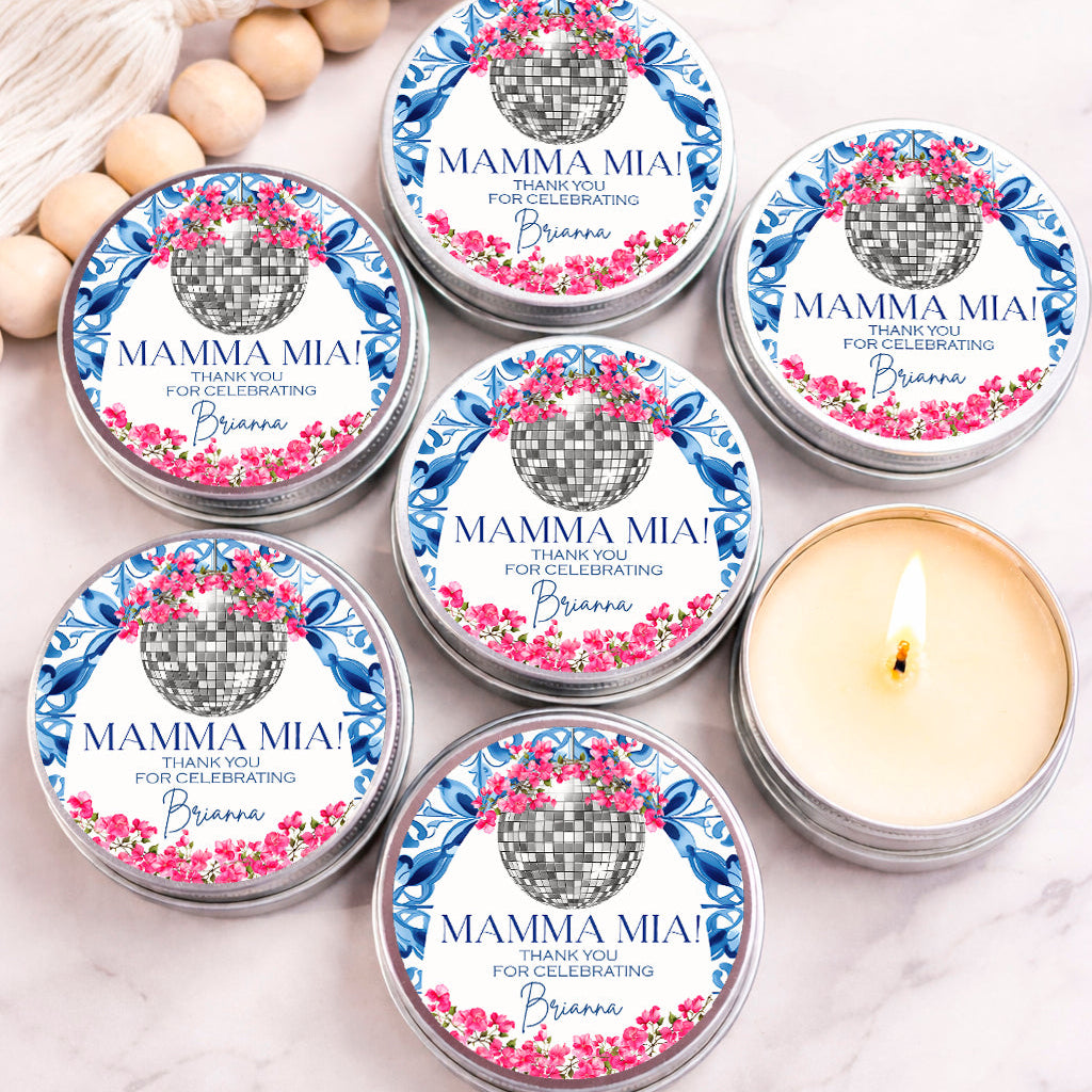 a collection of six silver tins with labels that say "MAMMA MIA! Thank you for celebrating Brianna" and feature a disco ball design. The tins are arranged on a marble surface, with one candle in the center.