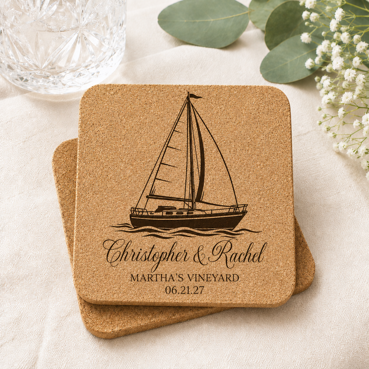 Personalized cork wedding coaster featuring engraved sailboat design with custom names, wedding location, and date on natural cork coaster.