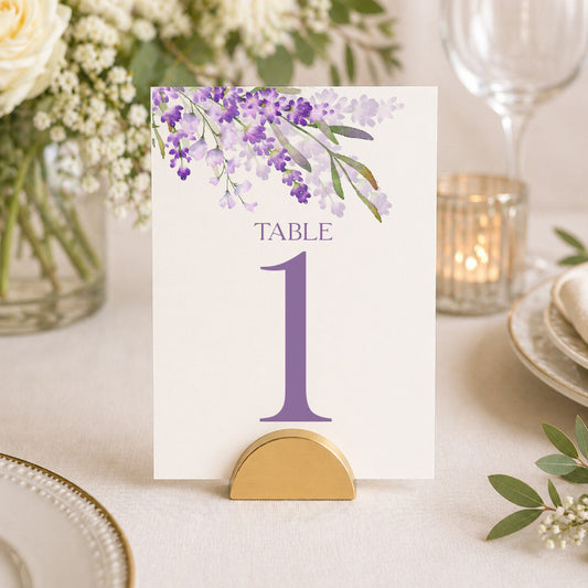 Lavender table number card with purple floral design displayed in gold stand on elegant wedding reception table