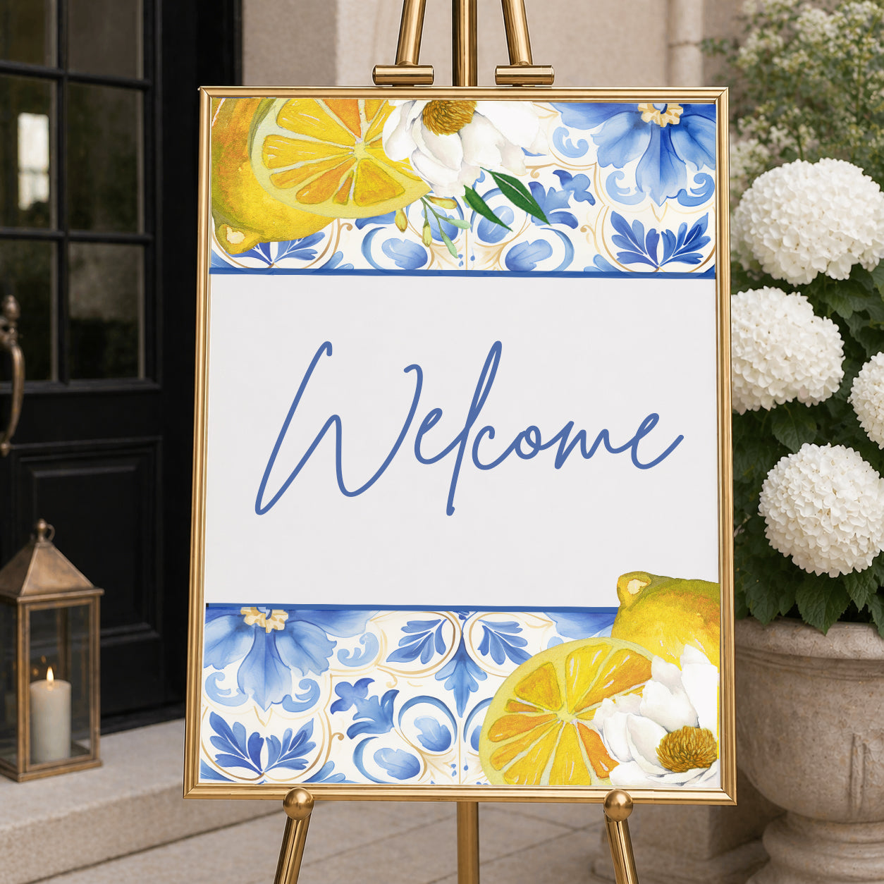 Amalfi Coast welcome sign with lemon illustrations and blue Mediterranean tile pattern displayed on easel, ideal for bridal shower or wedding entrance decor.