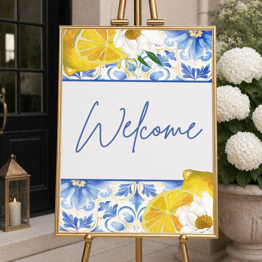 Amalfi Coast welcome sign with lemon illustrations and blue Mediterranean tile pattern displayed on easel, ideal for bridal shower or wedding entrance decor.